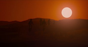 Movie still from “E.T. the Extra-Terrestrial” (1982), directed by Steven Spielberg – A group of people riding bikes on top of a hill at sunset; Extreme Wide shot, Low angle