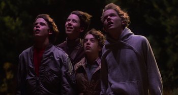 Movie still from “E.T. the Extra-Terrestrial” (1982), directed by Steven Spielberg – A group of young men standing next to each other; Medium shot, Low angle
