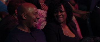 Movie still from “Chappelle's Home Team - Earthquake: Legendary” (2022), directed by Stan Lathan – A man and a woman laughing together in front of an audience; Close Up shot, High angle