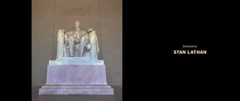 Movie still from “Chappelle's Home Team - Earthquake: Legendary” (2022), directed by Stan Lathan – A statue of abraham lincoln sitting on a pedestal; Wide shot, Low angle
