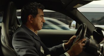 Movie still from “Easter Sunday” (2022), directed by Jay Chandrasekhar – A man in a suit and tie driving a car; Close Up shot, Over the shoulder angle