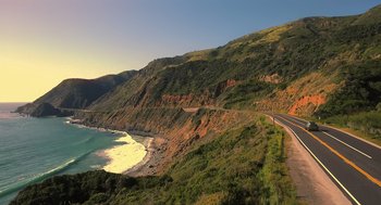 Movie still from “Easter Sunday” (2022), directed by Jay Chandrasekhar – A view of the ocean from the side of a road; Extreme Wide shot, High angle