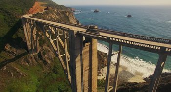 Movie still from “Easter Sunday” (2022), directed by Jay Chandrasekhar – An aerial view of a bridge over a body of water; Extreme Wide shot, High angle