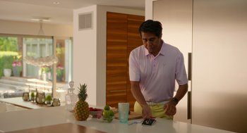 Movie still from “Easter Sunday” (2022), directed by Jay Chandrasekhar – A man standing at a counter cutting a pineapple; Medium shot, Low angle