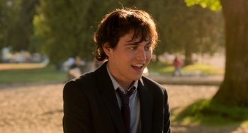 Movie still from “Easter Sunday” (2022), directed by Jay Chandrasekhar – A man in a suit and tie smiling for the camera; Close Up shot, Over the shoulder angle