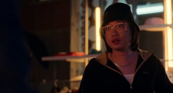 Movie still from “Easter Sunday” (2022), directed by Jay Chandrasekhar – A woman wearing glasses and a hat is standing in a room; Close Up shot, Over the shoulder angle