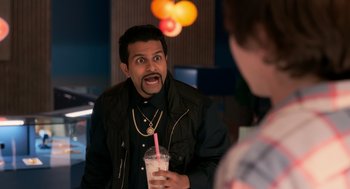 Movie still from “Easter Sunday” (2022), directed by Jay Chandrasekhar – A man holding a drink in his hand and making a funny face; Medium shot, Over the shoulder angle