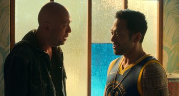 Movie still from “Easter Sunday” (2022), directed by Jay Chandrasekhar – Two men are standing next to each other in front of a window; Medium shot, Over the shoulder angle