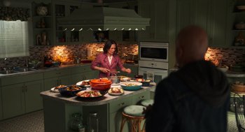 Movie still from “Easter Sunday” (2022), directed by Jay Chandrasekhar – A woman standing in a kitchen preparing food; Wide shot, Over the shoulder angle