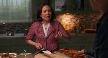 Movie still from “Easter Sunday” (2022), directed by Jay Chandrasekhar – A woman in a kitchen cutting food with a large knife; Medium shot, Over the shoulder angle