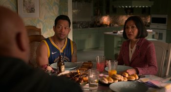Movie still from “Easter Sunday” (2022), directed by Jay Chandrasekhar – A man and a woman sitting at a table with plates of food on it; Medium shot, Over the shoulder angle