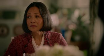 Movie still from “Easter Sunday” (2022), directed by Jay Chandrasekhar – An older woman sitting at a table with a vase of flowers in front of her; Close Up shot, Over the shoulder angle