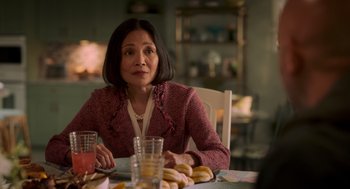 Movie still from “Easter Sunday” (2022), directed by Jay Chandrasekhar – A woman sitting at a table with a plate of donuts; Close Up shot, Over the shoulder angle