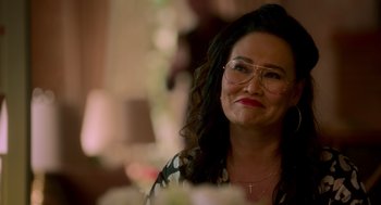 Movie still from “Easter Sunday” (2022), directed by Jay Chandrasekhar – A person wearing glasses and smiling; Close Up shot, Over the shoulder angle