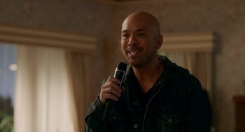 Movie still from “Easter Sunday” (2022), directed by Jay Chandrasekhar – A bald man holding a microphone in his hand; Close Up shot, Over the shoulder angle