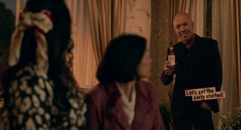 Movie still from “Easter Sunday” (2022), directed by Jay Chandrasekhar – A group of people standing in a living room; Medium shot, Over the shoulder angle