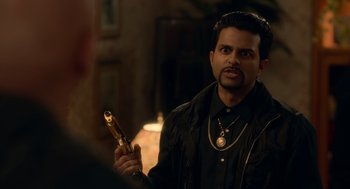 Movie still from “Easter Sunday” (2022), directed by Jay Chandrasekhar – A man in a black jacket holding a gun; Medium shot, Over the shoulder angle
