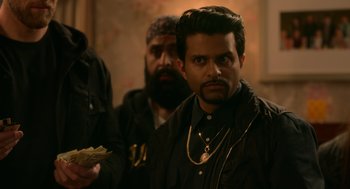 Movie still from “Easter Sunday” (2022), directed by Jay Chandrasekhar – A man with a beard is holding money in his hand; Close Up shot, Over the shoulder angle