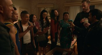 Movie still from “Easter Sunday” (2022), directed by Jay Chandrasekhar – A group of people standing in a living room; Medium shot, High angle