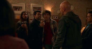 Movie still from “Easter Sunday” (2022), directed by Jay Chandrasekhar – A group of people standing around a room; Medium shot, Over the shoulder angle
