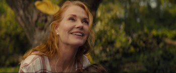 Movie still from “A Dog's Journey” (2019), directed by Gail Mancuso – A person smiling with trees in the background; Close Up shot, Low angle