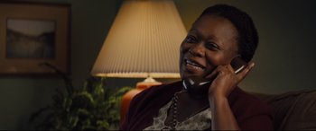 Movie still from “A Dog's Journey” (2019), directed by Gail Mancuso – A woman talking on a cell phone while sitting in a chair; Close Up shot, Over the shoulder angle