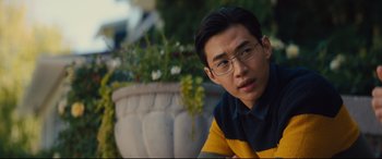 Movie still from “A Dog's Journey” (2019), directed by Gail Mancuso – A man with glasses sitting in front of a flower pot; Close Up shot, Over the shoulder angle