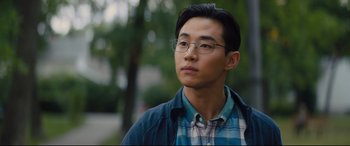 Movie still from “A Dog's Journey” (2019), directed by Gail Mancuso – A young man wearing glasses and a plaid shirt looks to his left; Close Up shot, Over the shoulder angle