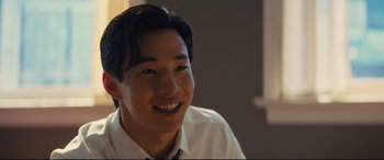 Movie still from “A Dog's Journey” (2019), directed by Gail Mancuso – A young man smiling for the camera in a white shirt; Close Up shot, Over the shoulder angle
