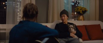 Movie still from “A Dog's Journey” (2019), directed by Gail Mancuso – A man sitting on a couch holding a dog; Medium shot, Over the shoulder angle