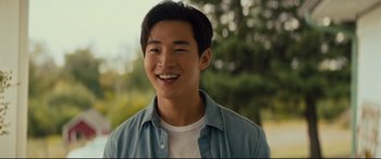 Movie still from “A Dog's Journey” (2019), directed by Gail Mancuso – A young asian man smiling for the camera outside; Close Up shot, Over the shoulder angle