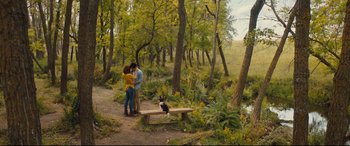 Movie still from “A Dog's Journey” (2019), directed by Gail Mancuso – Two people kissing on a bench in the woods; Wide shot, High angle