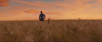 Movie still from “A Dog's Journey” (2019), directed by Gail Mancuso – A man standing in the middle of an open field; Extreme Wide shot, Low angle