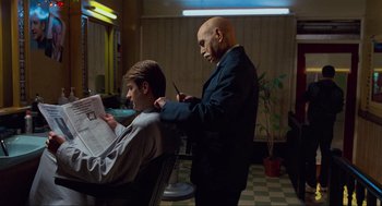 Movie still from “Eastern Promises” (2007), directed by David Cronenberg – A bald man cutting a man's hair in a barber shop; Medium shot, Over the shoulder angle