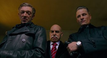 Movie still from “Eastern Promises” (2007), directed by David Cronenberg – A group of men standing next to each other in a room; Medium shot, Low angle