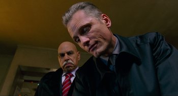 Movie still from “Eastern Promises” (2007), directed by David Cronenberg – A man in a suit and tie next to another man in a suit and tie; Close Up shot, Low angle
