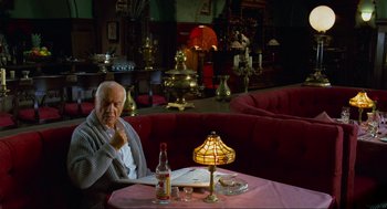 Movie still from “Eastern Promises” (2007), directed by David Cronenberg – An older man sitting at a table in a restaurant; Wide shot, High angle