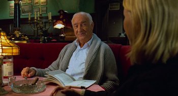 Movie still from “Eastern Promises” (2007), directed by David Cronenberg – An older man sitting at a table with a woman; Medium shot, Over the shoulder angle