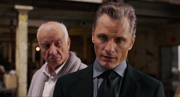Movie still from “Eastern Promises” (2007), directed by David Cronenberg – A man in a suit and tie standing next to another man in a suit and tie; Close Up shot, Over the shoulder angle