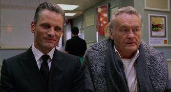 Movie still from “Eastern Promises” (2007), directed by David Cronenberg – Two men in suits and ties sitting next to each other; Close Up shot, Over the shoulder angle