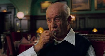 Movie still from “Eastern Promises” (2007), directed by David Cronenberg – An older man is eating something while sitting at a table; Close Up shot, Over the shoulder angle