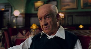 Movie still from “Eastern Promises” (2007), directed by David Cronenberg – An older man sitting in a chair in a room; Close Up shot, Over the shoulder angle