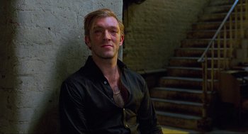 Movie still from “Eastern Promises” (2007), directed by David Cronenberg – A man sitting in front of a wall with stairs; Close Up shot, High angle