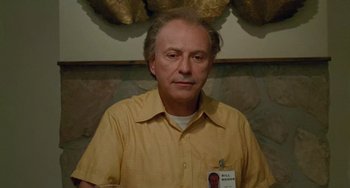 Movie still from “Edward Scissorhands” (1990), directed by Tim Burton – A man in a yellow shirt with a name tag; Close Up shot, Low angle