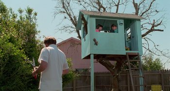 Movie still from “Edward Scissorhands” (1990), directed by Tim Burton – A man standing in front of two children in a tree house; Wide shot, Low angle
