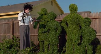 Movie still from “Edward Scissorhands” (1990), directed by Tim Burton – A group of topiaries that are in the shape of people; Wide shot, Low angle