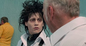 Movie still from “Edward Scissorhands” (1990), directed by Tim Burton – A man is looking at himself in the mirror; Close Up shot, Over the shoulder angle