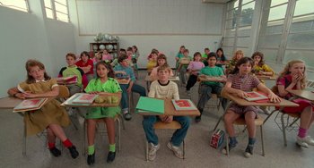 Movie still from “Edward Scissorhands” (1990), directed by Tim Burton – A group of children sitting at desks in a classroom; Wide shot, High angle