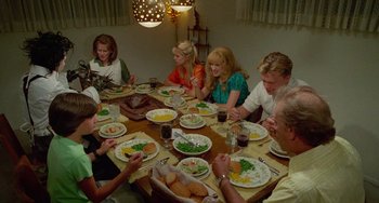 Movie still from “Edward Scissorhands” (1990), directed by Tim Burton – A group of people sitting around a dinner table; Medium shot, High angle