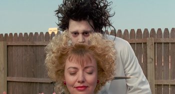 Movie still from “Edward Scissorhands” (1990), directed by Tim Burton – A man and a woman are getting their hair combed; Close Up shot, Over the shoulder angle